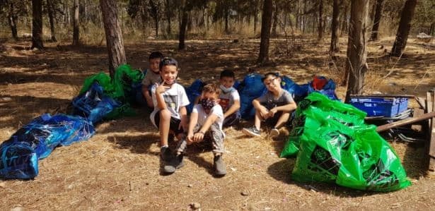 הילדים אוספים אשפה ומנקים את יער בן שמן