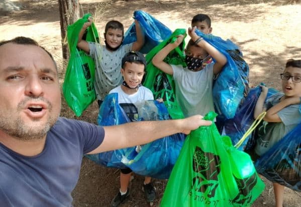 הילדים אוספים אשפה ומנקים את יער בן שמן