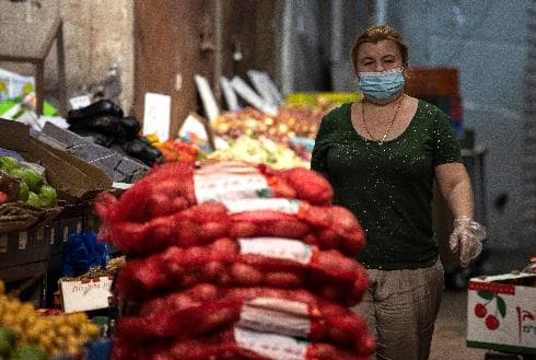 עסקים לא כרגיל. עובדת בחנות ירקות בשוק הישן באשקלון מנסה לתמרן בין ההנחיות המבלבלות של הסגר (צילום: צפריר אביוב) עסקים לא כרגיל. עובדת בחנות ירקות בשוק הישן באשקלון מנסה לתמרן בין ההנחיות המבלבלות של הסגר