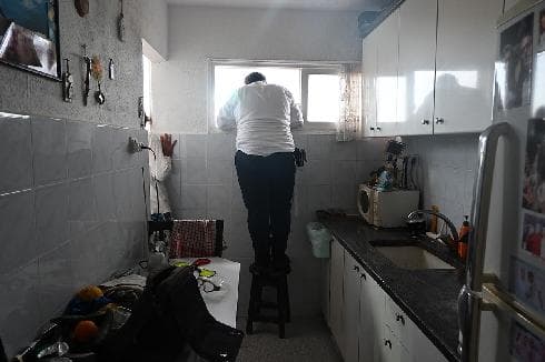 כדורגל בלי קהל. אוהד מ.ס. אשדוד צופה במשחק של קבוצתו דרך החלון