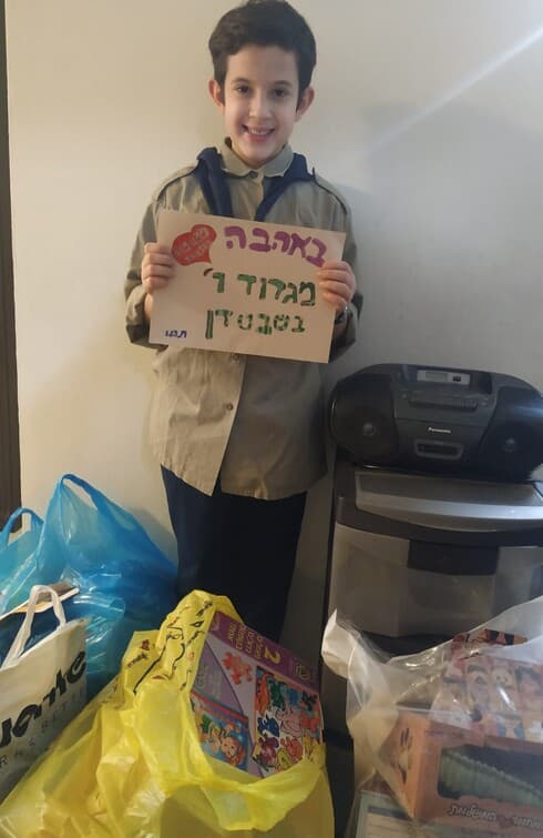 נדב בוטנר עם המתנות שאסף 