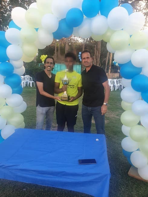 רוני לוי (מימין) ויוסי בניון מעניקים גביע לאחד הנערים. פרויקט חשוב