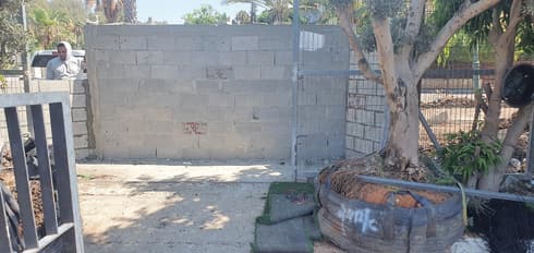 "אחד העובדים איים עלי ואמר לי 'אל תתקרב לפה, אני אדקור אותך'.. החומה שהוצבה השבוע (צילום: רועי נדלר) חוסמת את שער הכנחסה. החומה שהוצבה השבוע