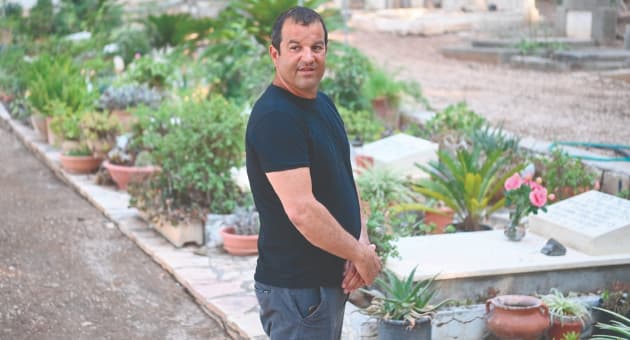 רון אשכנזי ליד קברי חבריו שנהרגו