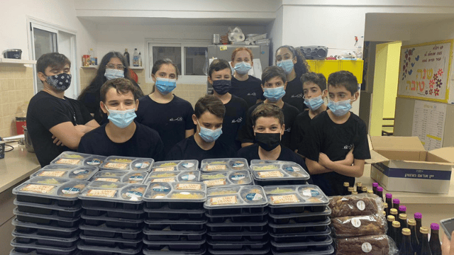 מבשלים באהבה למי שזקוק. נערי קיבוץ כפר המכבי עוזרים לארוז את המזון שבושל לתרומה