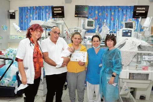 מורן ומוטי אברג'ל עם התינוק איתן שמעון וצוות הפגייה 