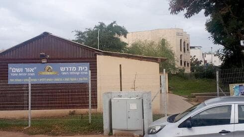 הצריף ובית הכנסת מאחוריו