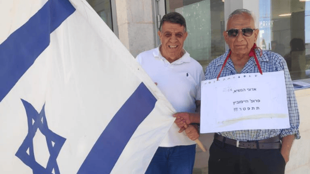 השופט בדימוס יוסף רבי (מימין) ואנדריי אוזן מפגינים בשער אוניברסיטת בן גוריון הבוקר (צילום: פרטי) השופט בדימוס יוסף רבי (מימין) ואנדריי אוזן מפגינים בשער אוניברסיטת בן גוריון הבוקר