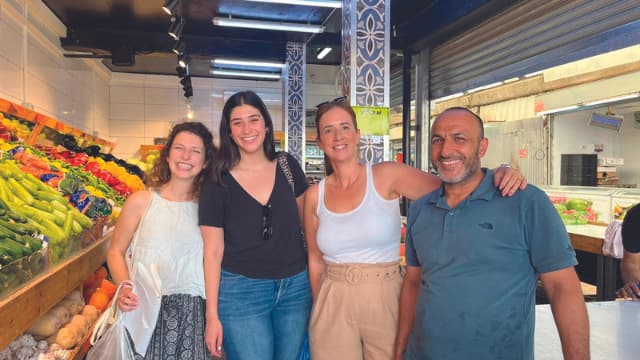 פעילי המיזם עם לב־קנפו באחת החנויות בשוק