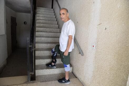אריה פרץ בכניסה לבניין בו הוא גר  
