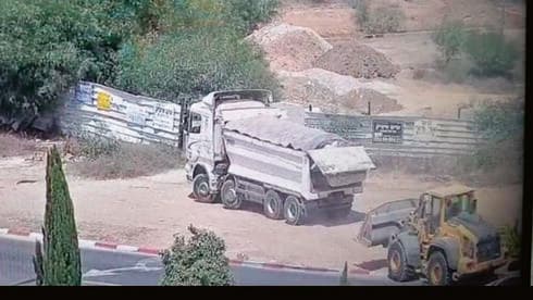 משאיות פורקות פסולת בעיר