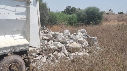 משאיות פורקות פסולת בעיר
