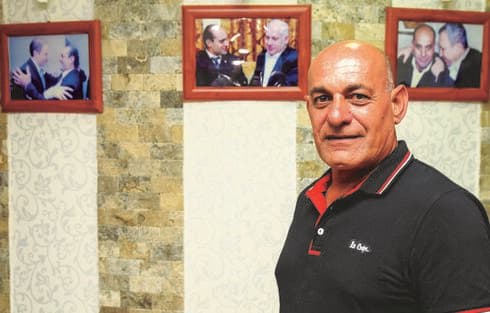 עזאם עם תמונותיהם של ברק, נתניהו ושרון. "קיבלתי הצעות פוליטיות" 