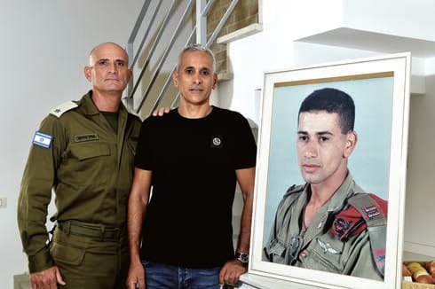 משמאל: אייל בז'רנו ושרון אלכאוי לצד תמונתו של רס"ן ערן אלכאוי