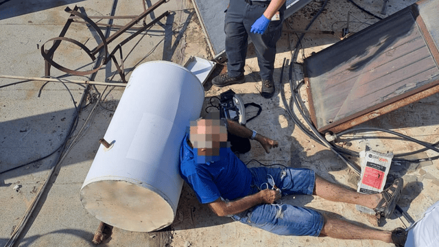 שבר רגל. הפצוע בגג הבניין (צילום: כבאות והצלה) הפצוע מגג הבניין