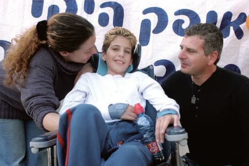 אטיאס בן ה־10 עם הוריו לאחר שהשתחרר מבית החולים