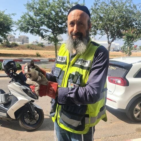 כהן בחילוץ חתול ממכסה מנוע בנתניה (צילום: דוברות ידידים) כהן בחילוץ חתול ממכסה מנוע בנתניה