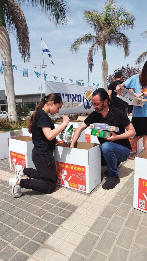 טל יצחק ובתו בחלוקת סלי מזון לזכר קורבנות הפיגוע