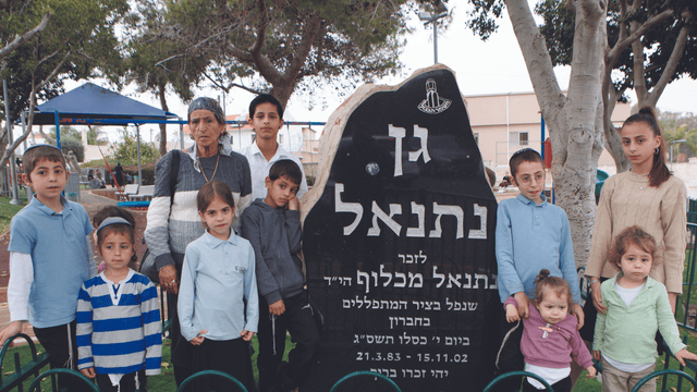 ציונה מכלוף ונכדיה ליד האנדרטה לזכר נתנאל מכלוף ז"ל