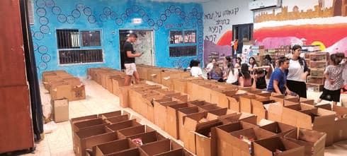 בני עקיבא מסייעים לעמותת עמירם בהכנת סלי מזון (צילום: פרטי) בני עקיבא מסייעים לעמותת עמירם בהכנת סלי מזון