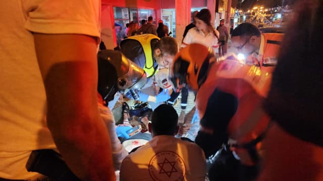 פרמדיקים מטפלים בפצוע בזירת הדקירה