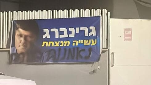 כתובת גרפיטי על שלט חוצות של רמי גרינברג