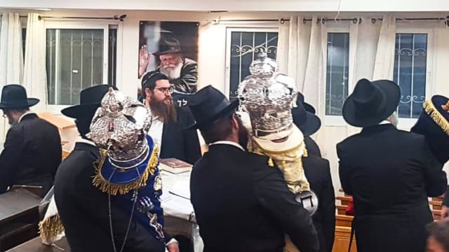 ספרי התורה והכתרים ברקע הרבי מלובביץ'