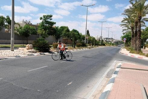 רוכב אופניים חוצה את הכביש במקום בו נפגע אביאל