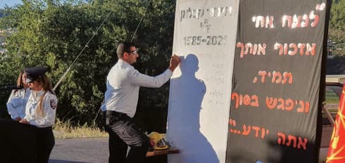 עדנאן כותב על השלט (צילום: פרטי) עדנאן כותב על השלט