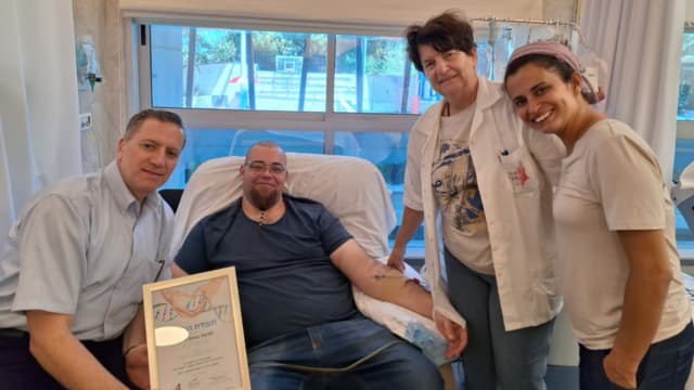 משה באום (במרכז) בבית החולים