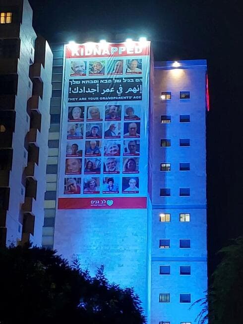 השלט הענק עם תמונות החטופים על לב גנים בנתניה