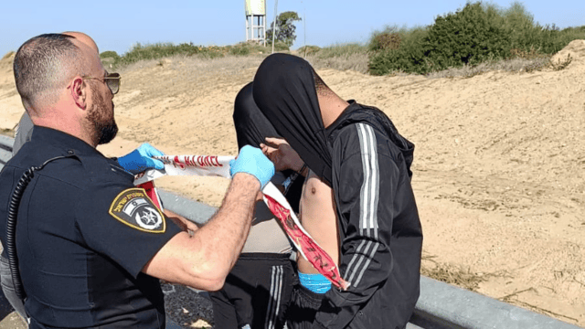 השוטרים עוצרים את שני השוהים הבלתי חוקיים