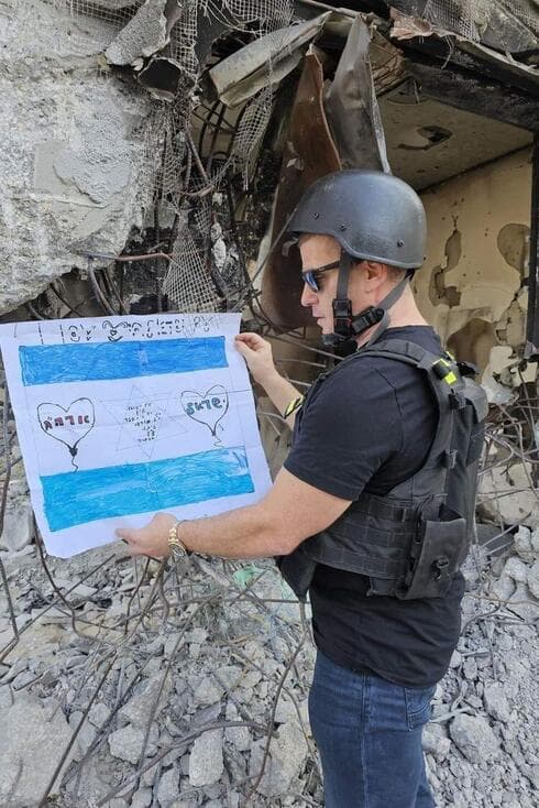 ירון לוי תולה דגל שהכינו תלמידי "יד מרדכי" בקיבוץ בארי 