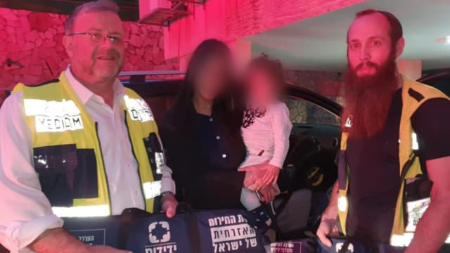 מתנדבי ידידים עם התינוק לאחר החילוץ