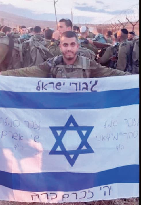 אפיק טרי ז"ל עם דגל ישראל לזכר חבריו שנפלו