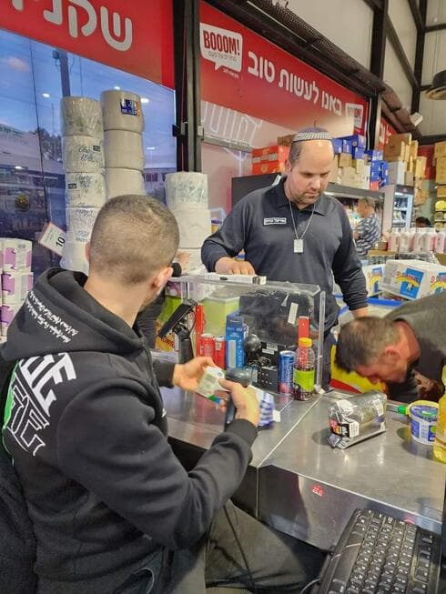 אורי זבידה (משמאל) במרכול בום