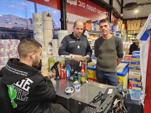 אורי זבידה (משמאל) במרכול בום