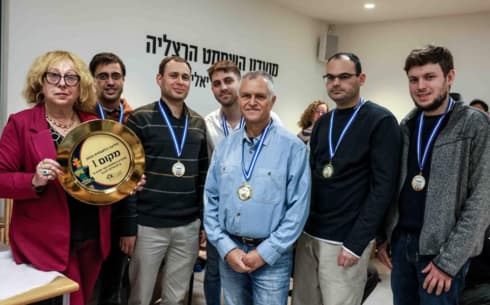 ראשת הקבוצה ומנהלת מועדון השחמט, גב' אילנה דוד ושחקני הקבוצה במעמד הזכיה. (צילום: ד"ר מרק ליבשיץ) ראשת הקבוצה ומנהלת מועדון השחמט, גב' אילנה דוד ושחקני הקבוצה במעמד הזכיה.