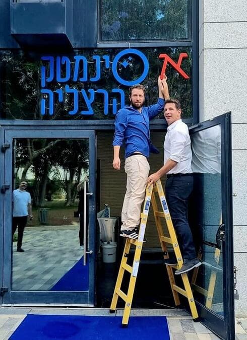 ליאור דיין וראש העיר הרצליה, יריב פישר, בהצבת האות א' בשלט סינמטק הרצליה ( צילום: דוברות עיריית הרצליה) ליאור דיין וראש העיר הרצליה, יריב פישר, בהצבת האות א' בשלט סינמטק הרצליה