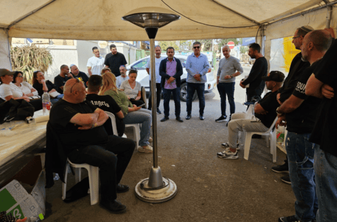 עובדי המפעל באוהל המחאה בפתח המפעל בנאות חובב