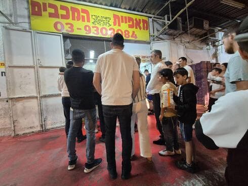תור לפיתות במאפיית המכבים בצאת פסח