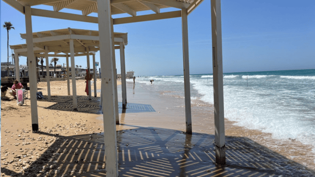יושבים בתוך המים. החופים בחיפה נעלמים (צילום: דורון סולומון) סוכות מציל מבטון באוויר. החופים בחיפה נעלמים