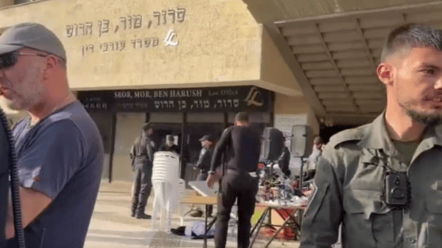 אירוע התרמה לעזה וברקע שלט משרד עורכי דין