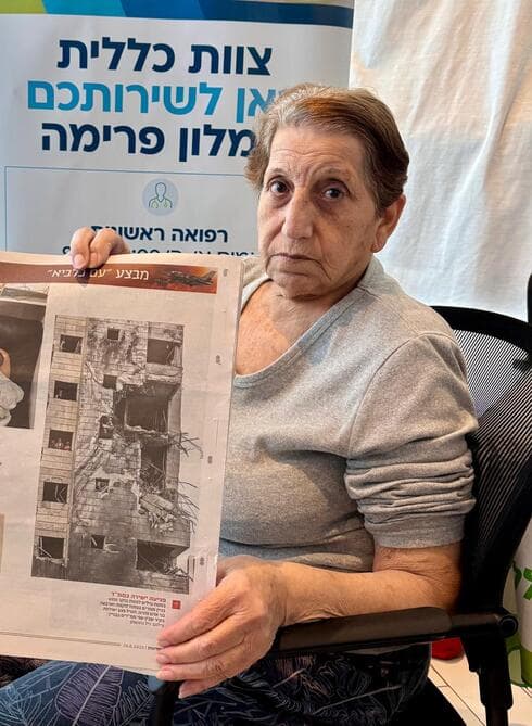 תקווה מזרחי עם תמונת הבניין שנפגע