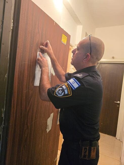 תליית הודעה על דלת הדירה בפתח תקוה