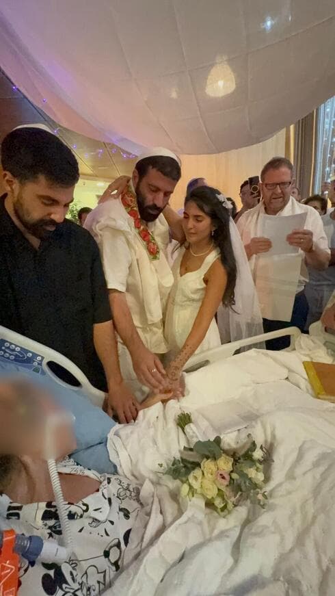 החתן והכלה בחופה לצד מיטתה של חפציבה