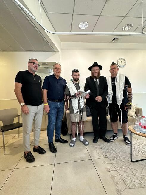 מתן הניח תפילין לראשונה מאז שובו לארץ (צילום: עיריית קרית ביאליק) במהלך הביקור הניח מתן תפילין לראשונה מאז שובו לארץ