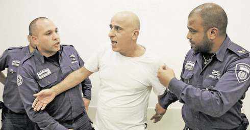 רוחן (במרכז) בבית המשפט. "פועל מתוך כותלי הכלא ללא הפסק" (צילום: שאול גולן)