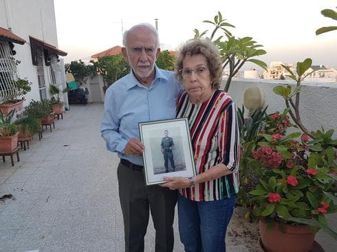 שמואל ורינה חזון עם תמונה של בנם ניב ז"ל. צילום: אייל עצמון