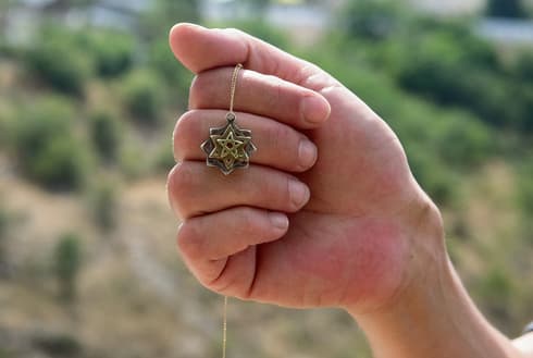 י' והתליון שקיבלה בחזרה. צילום: יואב דודקביץ'